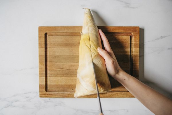 竹筍直劃一刀，剝去筍殼。