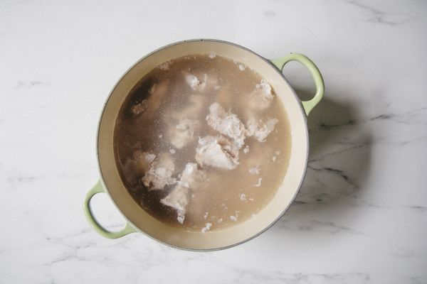 將排骨放入冷水（1）中，以小火慢慢煮出血水，在滾沸前撈起、稍稍沖洗備用。