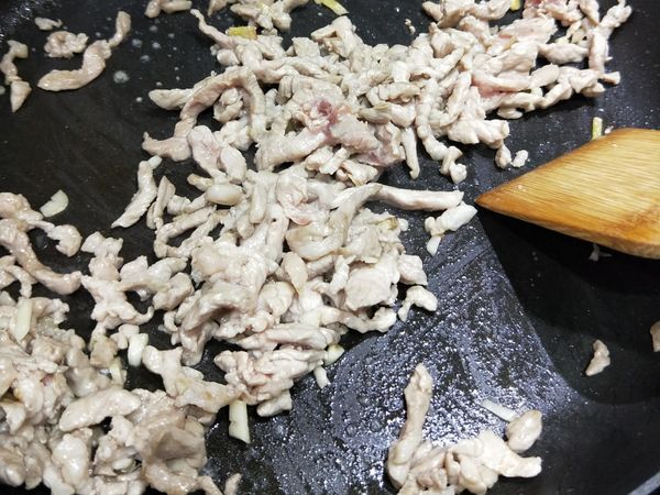 將糯米椒先撈起來，放入肉絲，炒香炒至肉變白色