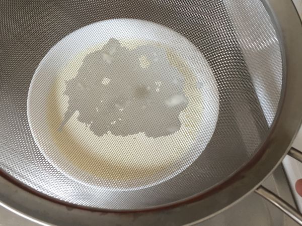 將煮開的鮮奶過篩倒入容器內