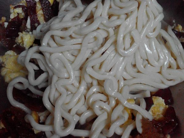 再下烏龍麵拌炒一下後加入水悶煮2分鐘