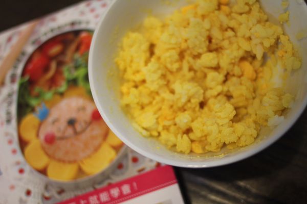 用保鮮模捏兩顆白飯糰，另外兩顆白飯糰一顆加蕃茄醬、一顆加水煮蛋黃。蕃茄飯糰與白飯糰，蛋黃飯糰與白飯糰結合起來捏成橢圓形。