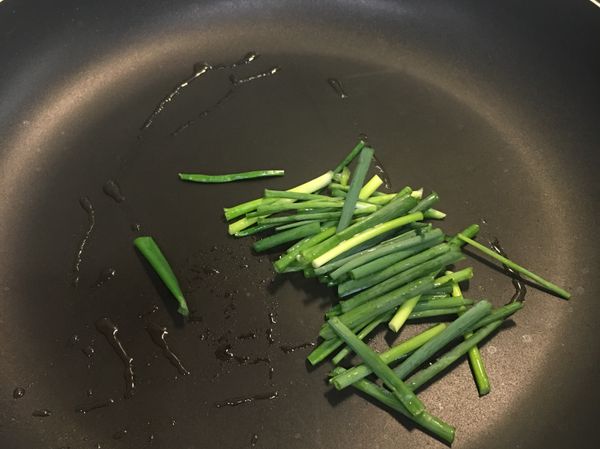 不沾鍋滴上3g的椰子油。
放上蔥段炒一下。