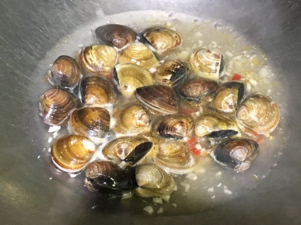 鍋內放入奶油，再倒入蒜末、辣椒末用中小火爆香1分鐘，再將蛤蜊、40cc的白酒及120cc的水倒入鍋內，煮約1-2分鐘至蛤蜊全開後撈起備用。