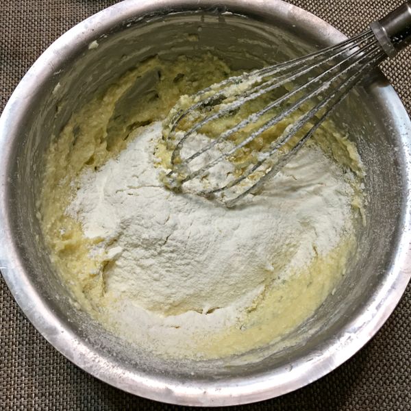 依序加入過篩的低筋麵粉，泡打粉，牛奶，香草精，檸檬汁，輕柔的拌勻。