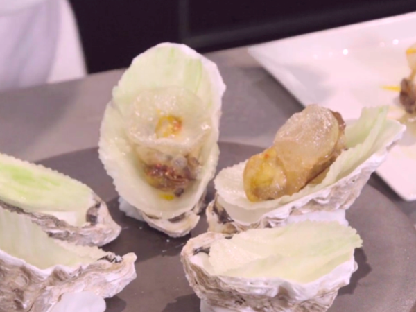 將燜完的生蠔放置在根據蠔殼大小剪成的美生菜上方。