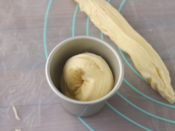 切面朝外，捲成圓形放入模具中。這裏使用布丁杯，也可直接使用馬芬烤盤。