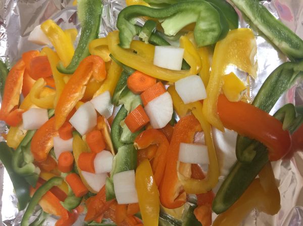 烤箱先預熱，華氏400度，此時烤盤上用鋁箔紙包住，上面擺放切斯的彩椒及切小塊的蘿蔔，灑上調味料、橄欖油、鹽巴胡椒粉、美極鮮味露灑上一圈，用手全部拌勻，放入烤盤烤上三十分鐘，完成。