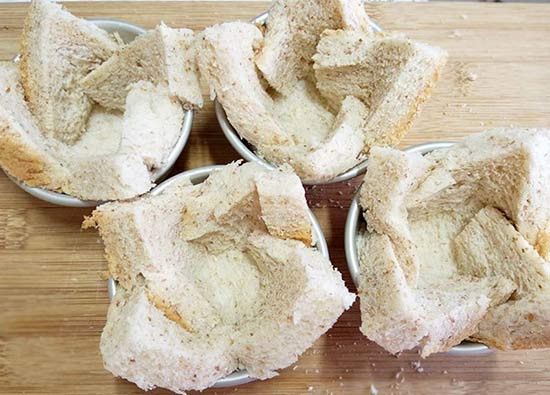 布丁模內刷上一層薄油，將吐司切線部份重疊後塞入模中，稍微壓實