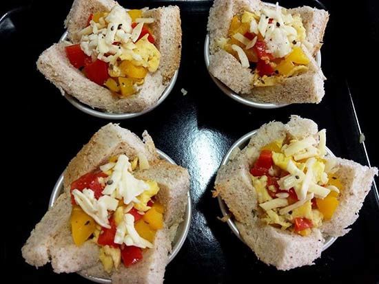 將餡料填入吐司杯中，表面放上少許焗烤起司絲