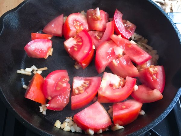原鍋倒入蒜末、蕃茄塊拌炒，可用煎鏟稍微壓一下蕃茄，擠出少許湯汁