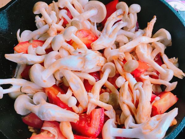 倒入菇菇，切好的豆包、酸甜醬汁一起拌炒一下，待食材稍微變軟，加入約2、3大匙的水煨煮，讓豆包吸飽湯汁