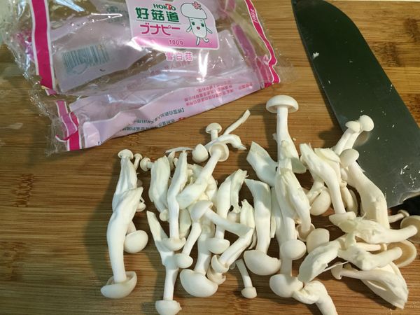 雪白菇取出半包，切除根部，撕成小株；適量九層塔葉洗淨備用；雞蛋2個打散成蛋液。