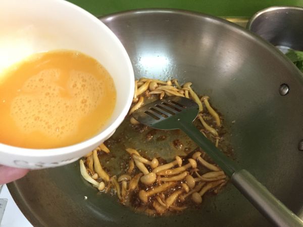 接著加入蛋液，先不翻炒，等底部稍微凝固成型再慢慢翻炒成塊。