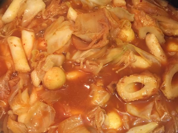 加入水、韓式年糕醬及泡菜，拌炒後加入竹輪、金針菇、魚蛋等喜歡的食材