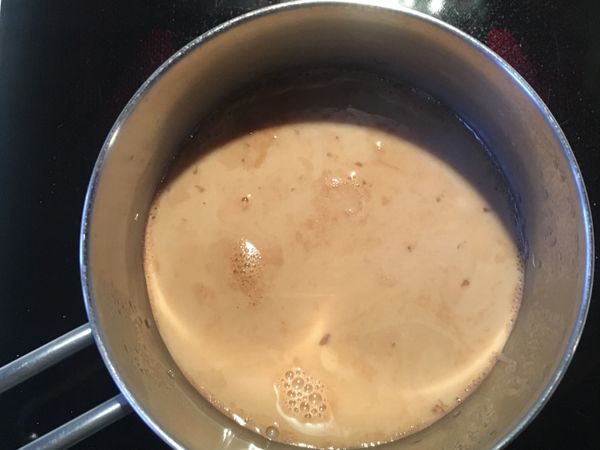 拿起茶包及隔走薑片後放入牛奶及黑糖，攪拌至冒出小氣泡便可關火。