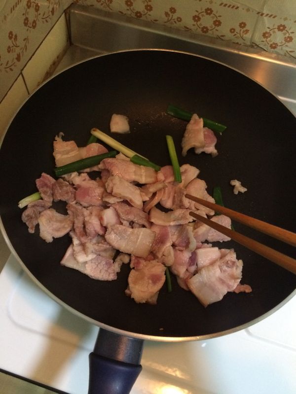 蔥和五花肉片一起下鍋炒，火不要太大，五花肉可以炒到有點微焦。不用放油了，五花肉本身就很多油脂。