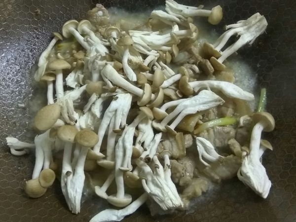 待蔥香味出來後，即可加入米酒拌炒一分鐘，之後再倒入適量的水(我大概加一米杯)加蓋燜煮，將肉煮軟一些

約3～5分鐘後，即可倒入鴻禧菇，再燜煮三分鐘，此時鍋底應該已剩一點點水份