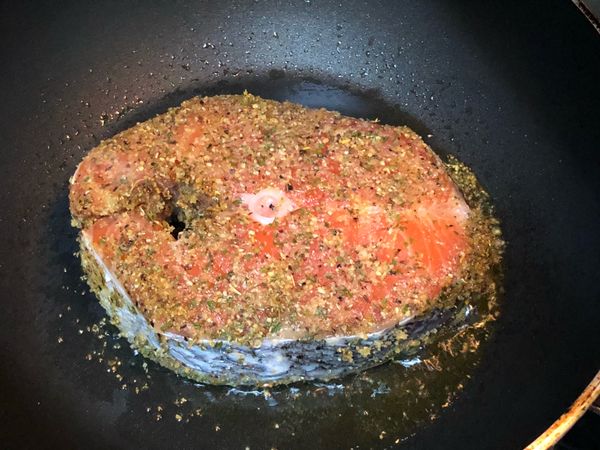 起油鍋中小火放入醃漬好的鮭魚，蓋上鍋蓋轉小火煎個10分鐘