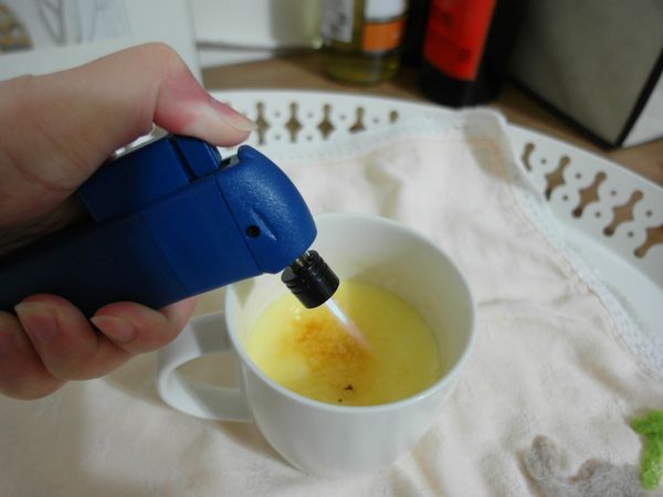 要吃的時候於布蕾表面灑上一層白細砂糖。再用噴槍燒烤糖粒，讓糖焦糖化，糖粒也會融成一塊薄磚。