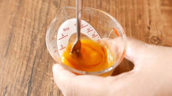 把蛋黃打散後，在蛋黃中加入蛋白至30毫升，再加入香草精，拌勻備用。