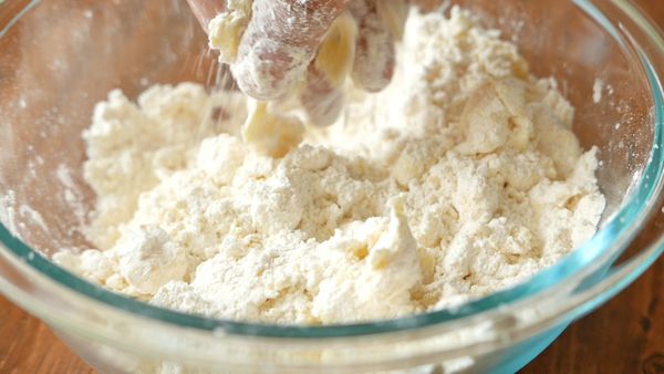 把奶油加入粉類材料中，以手指頭捏成麵包糠狀。