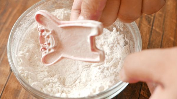 讓曲奇模沾上高筋麵粉，敲敲曲奇模去掉多餘的麵粉。