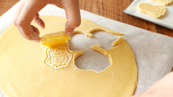 撕走麵團上的一張烘焙紙後，在麵團上以曲奇模印出曲奇。印出曲奇後剩下的麵團可以再捏成一團，重覆桿、冷藏和印模的步驟做出更多曲奇。