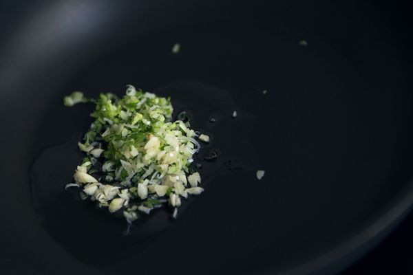 蕃茄切成小丁，雞蛋拌打至表面起泡備用。熱鍋後下炒油（1），旋轉一下讓油布敷整個鍋面，放入蔥花與蒜碎炒出香氣，倒入蕃茄丁炒至出湯汁，加入糖與一大匙水。