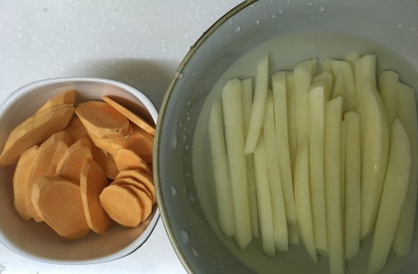 馬鈴薯去皮切條後泡冷水10分鐘備用，地瓜去皮切片備用