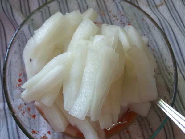 將料理碗內的漬醬拌勻。將殺青的白蘿蔔條擠乾澀水，放入料理碗內。