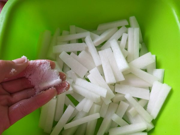 抓一小把鹽巴和白蘿蔔條拌勻，做殺青動作，靜置10分鐘。