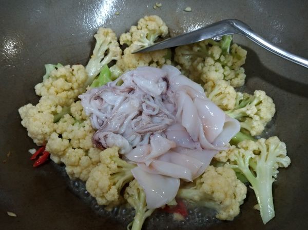 鍋內先將油加熱，小火將蒜末和辣椒先爆香，接著放入花椰菜轉大火拌炒約一至兩分鐘，續入花枝，再加入魚露再炒約一分鐘即可。