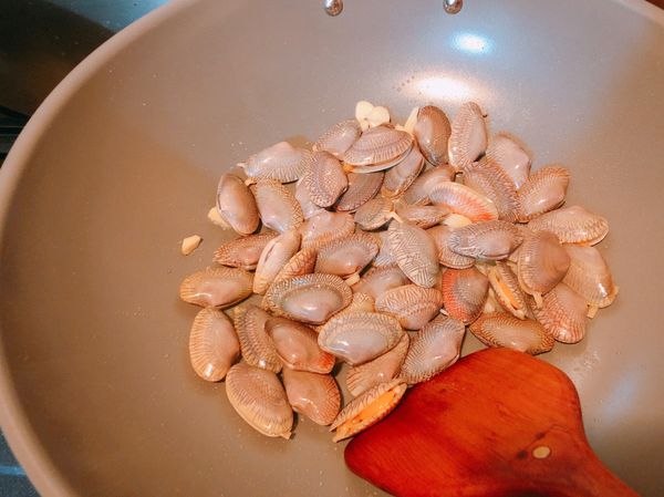 蒜頭爆香後加入海瓜子，並加入3瓶蓋米酒及2大匙醬油拌炒