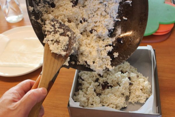 趁熱將米香倒入模型裡。稍稍型壓平，不要壓的太用力，這樣會變的太硬，不鬆脆。其實不會燙，可以用手幫忙整型。