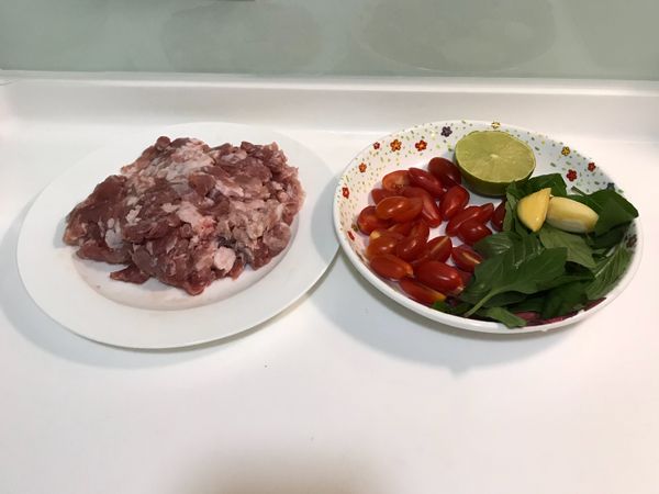 九層塔洗好，取下葉子；小蕃茄對半切；檸檬擠成檸檬汁；蒜頭、辣椒切碎備用。