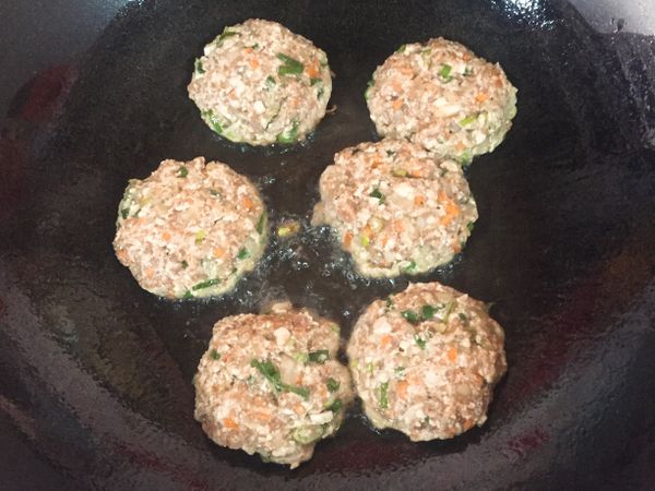 以中油溫將肉餅下鍋，不宜著急翻面，以筷子翻動感受肉餅受熱那面是否變硬，變硬即可翻面。