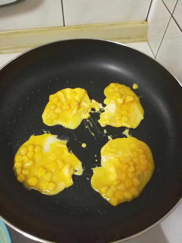開小火熱鍋，以餐巾紙塗抹少量油在鍋底，下玉米粒蛋液