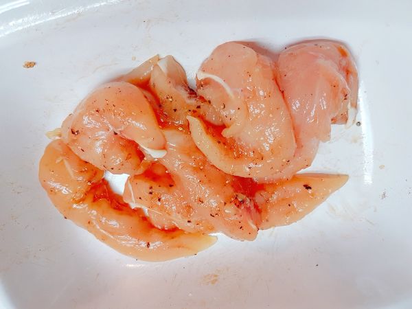 首先！雞里肌肉把水分吸乾，灑一些黑胡椒以及辣椒粉，還有一點點鹽巴，一小匙米酒，抓醃！（我有戴手套抓醃喔）