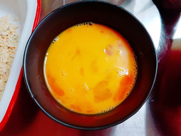 打一顆蛋，加一小匙鹽巴跟味醂，然後將里肌肉沾取蛋液