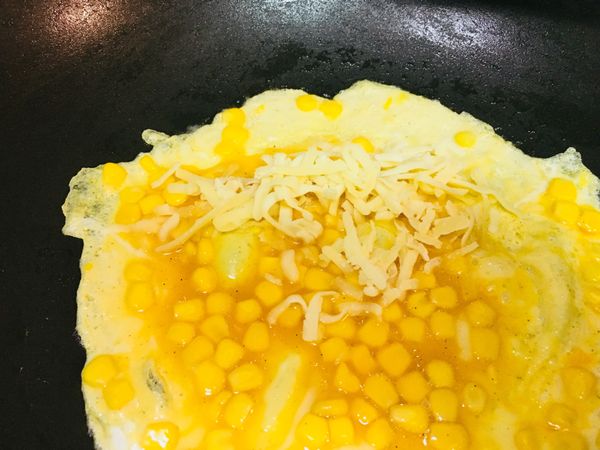 將起司放在側邊處，並由起司處開始向內捲起，鍋子可以稍微為傾斜，會比較好捲起