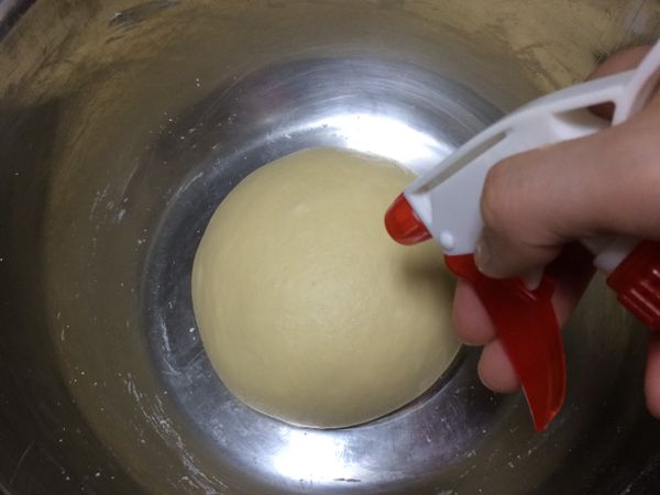 將麵團滾圓放入鋼盆中，表面噴點水蓋上保鮮膜發酵60分鐘。