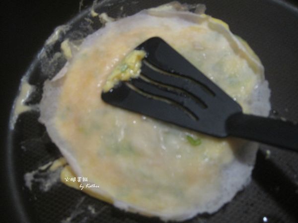 趁蛋還是半熟狀態時趕緊把餅皮鋪上，讓他和蛋黏在一起。