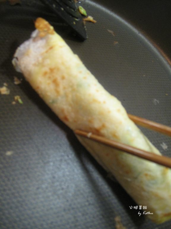 蛋餅捲好之後在開口的地方熱一下，讓開口稍微可以黏起來。