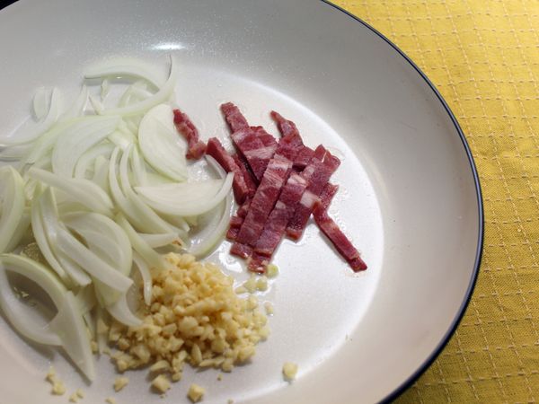 取一炒鍋, 加入2大匙油, 蒜頭, 洋蔥及培根, 小火煸出天然油脂釋出, 聞到香氣