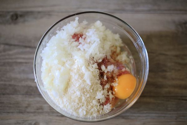 豬絞肉先加米酒與水攪拌吸收，再加入切碎的洋蔥丁、麵包粉、一顆雞蛋、鹽與黑胡椒攪拌均勻至產生黏性。