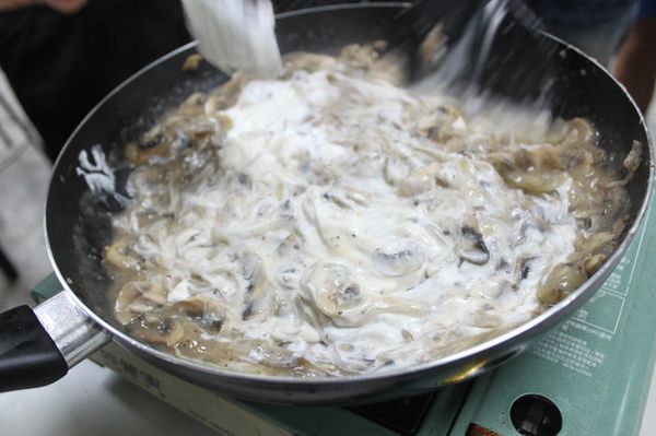 待炒鍋中的洋菇稍微出水，加入3大匙中筋麵粉，並加入約250克的水，再加入酸奶油（sour cream）稍微勾芡至呈現糊燴狀。