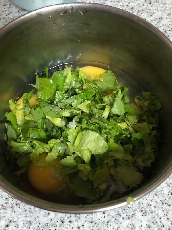 將芹菜葉切碎放入打好蛋的鍋中，加入適量的鹽，打散拌勻
