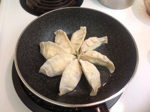 不沾鍋中放入約1大匙的油,中火,油溫稍微上來後,就可以把餃子排列在鍋中