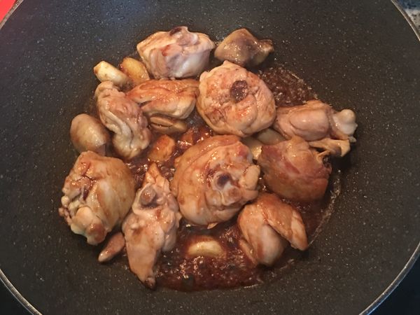 放入糖炒勻後加入醬油，將雞肉炒上色。